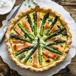 Smoked salmon asparagus quiche in a golden crust, served with fresh herbs
