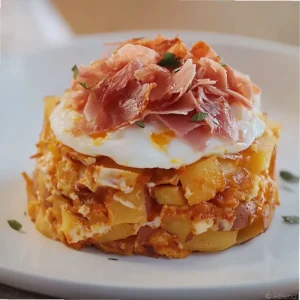 Huevos rotos with turkey ham featuring crispy fried potatoes, runny eggs, and thin slices of turkey ham on a white plate